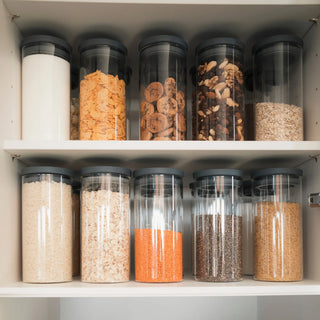 Perfekt organisierter Vorratsschrank mit zwei Reihen 1000ml Gläsern; einheitlicher Look für Mehl, Zucker, Reis, Linsen und Cornflakes.