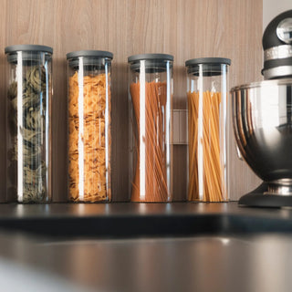 Vier hohe 1700ml Pastagläser der HATTY HAYS Classic Edition gefüllt mit Spaghetti und Tagliatelle an einer modernen Küchenwand.