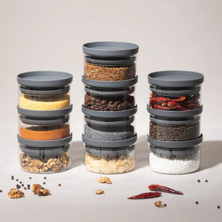 Drei Türme aus gestapelten 160ml Gläsern zeigen die Rutschfestigkeit der anthrazitfarbenen Holzdeckel; ideal für Polenta, Kurkuma und Gewürze.