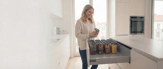 Helle minimalistische Küche mit HATTY HAYS Vorratsglas System in einer organisierten Schublade; stapelbare Vorratsdosen aus Borosilikatglas für Ordnung und Ästhetik.